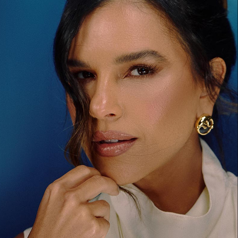Editorial beauty portrait featuring sculptural organic gold earrings